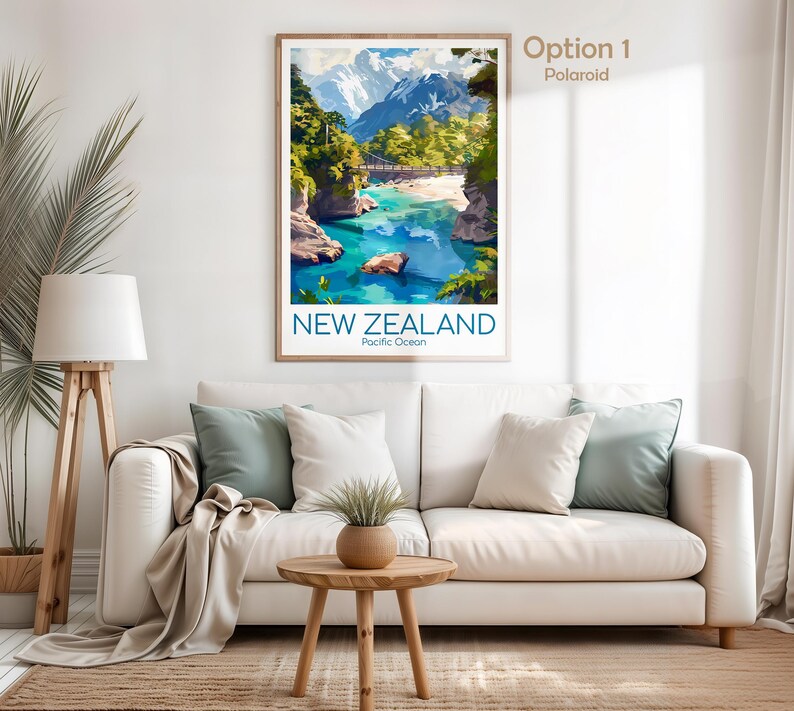 Puede incluir: Una impresi&oacute;n de arte mural vertical enmarcada con una ilustraci&oacute;n de paisaje de Nueva Zelanda con monta&ntilde;as nevadas, un puente colgante y un r&iacute;o turquesa. El texto NEW ZEALAND y Pacific Ocean est&aacute; impreso en azul en la parte inferior.