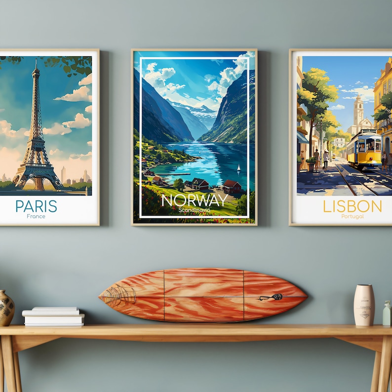 May include: Three framed travel posters with vintage-style illustrations of Paris, Norway, and Lisbon. The Paris poster features the Eiffel Tower, the Norway poster shows a fjord, and the Lisbon poster depicts a street scene with a yellow tram.