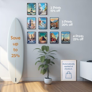 May include: A collection of framed travel art prints featuring iconic landmarks like the Eiffel Tower, Santorini, and the New York Statue of Liberty. The prints are displayed on a gray wall with a surfboard and a plant. Text on the wall indicates discounts.