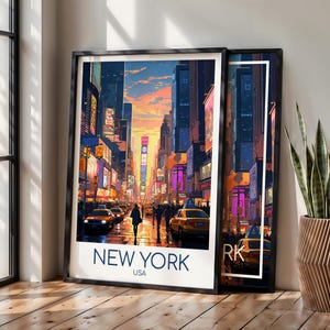 May include: A framed art print featuring a vibrant illustration of a New York City street scene at sunset, with yellow taxis, tall buildings, and glowing billboards. The text NEW YORK USA is printed in bold blue letters at the bottom of the white border.