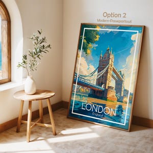 May include: A framed art print featuring the Tower Bridge in London, England, with a blue sky and water. The print has a white border and a wooden frame. The word "LONDON" is displayed prominently at the bottom.