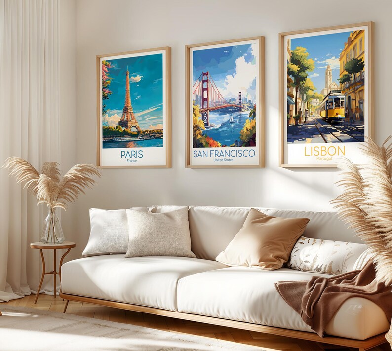 May include: Three framed travel art prints featuring iconic landmarks: the Eiffel Tower in Paris, the Golden Gate Bridge in San Francisco, and a street scene in Lisbon. Each print has a light wood frame and includes the city name.
