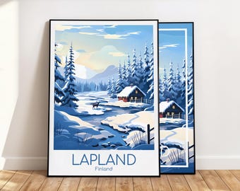 May include: Two framed art prints featuring a winter landscape scene. The artwork depicts snow-covered trees, a river, and cabins under a blue sky. The word "LAPLAND" is printed at the bottom, with "Finland" below it.