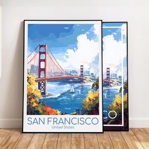 May include: Two framed art prints featuring the Golden Gate Bridge in San Francisco. The artwork depicts the bridge in a colorful, stylized illustration with a blue sky, water, and a sailboat. The text "SAN FRANCISCO United States" is at the bottom.