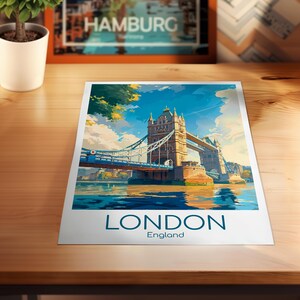 May include: A colorful print of the Tower Bridge in London, England, with the word "LONDON" and "England" printed at the bottom. The artwork depicts the bridge over water under a blue sky with clouds.
