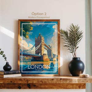 May include: A framed art print featuring the Tower Bridge in London, England. The artwork has a vintage travel poster style with a blue, white, and gold color scheme. The word "LONDON" is displayed prominently at the bottom of the image.