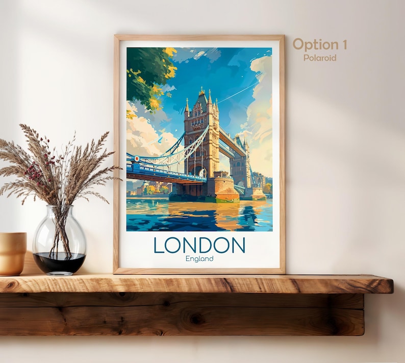 May include: A framed art print featuring the Tower Bridge in London, England. The artwork depicts the bridge over the water with a blue sky and clouds. The word "LONDON" is printed in large letters at the bottom.