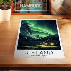 May include: A print featuring a landscape of Iceland under the Northern Lights. The image shows a cabin with lit windows, mountains, and green and white aurora borealis. The word "ICELAND" and "Northern Lights" are printed at the bottom.