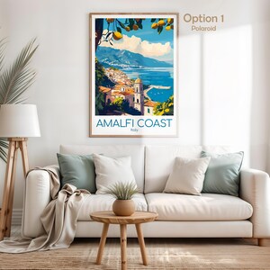 Pu&ograve; includere: Una stampa artistica da parete verticale incorniciata con un'illustrazione colorata della Costiera Amalfitana in Italia, con acqua blu, montagne e limoni gialli in primo piano. Il testo AMALFI COAST Italy &egrave; stampato in blu in basso.