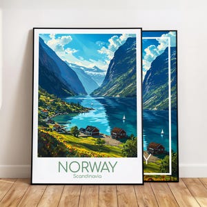 May include: A framed travel poster featuring a vibrant illustration of a Norwegian fjord with steep mountains, blue water, small red houses, and sailboats. The text at the bottom reads NORWAY Scandinavia in a clean, sans-serif font.