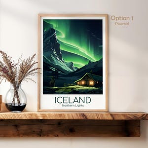 May include: Framed art print of Iceland's Northern Lights. The artwork depicts a cabin with lit windows under a vibrant green aurora borealis. The word "ICELAND" is printed in bold, with "Northern Lights" below.