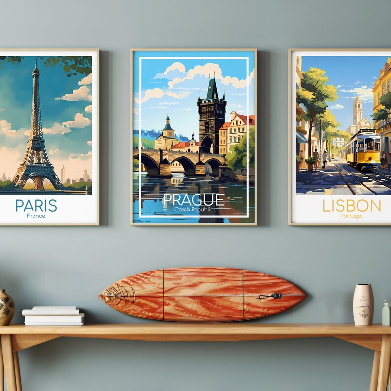 Puede incluir: Tres p&oacute;sters de viaje enmarcados con ilustraciones coloridas de monumentos emblem&aacute;ticos. Los p&oacute;sters presentan Par&iacute;s, Praga y Lisboa con el nombre de la ciudad y el pa&iacute;s que figuran debajo de cada imagen.