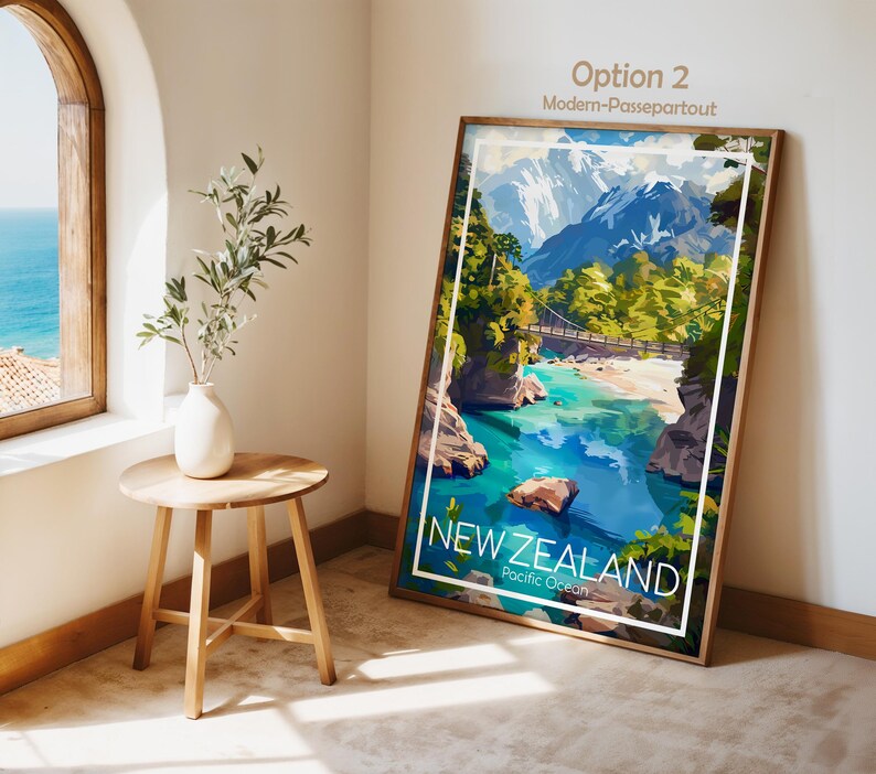 Puede incluir: Una impresi&oacute;n art&iacute;stica vertical enmarcada que presenta una vibrante ilustraci&oacute;n paisaj&iacute;stica de Nueva Zelanda con agua turquesa, un puente colgante y monta&ntilde;as nevadas. El texto NEW ZEALAND Pacific Ocean est&aacute; impreso en blanco.