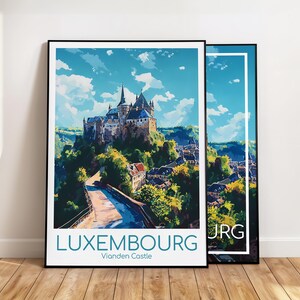 Può includere: Due stampe artistiche incorniciate raffiguranti una vista panoramica del Castello di Vianden in Lussemburgo. L'opera d'arte raffigura il castello in cima a una collina, con una strada che vi conduce, sotto un cielo blu con nuvole. Le parole "LUXEMBOURG" e "Vianden Castle" sono stampate in basso.