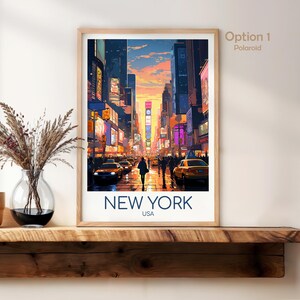 May include: A framed vertical art print featuring a vibrant illustration of a New York City street scene at sunset with yellow taxis, tall buildings, and glowing billboards. The text NEW YORK USA is printed in dark blue at the bottom of the white border.