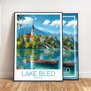 Könnte beinhalten: Zwei gerahmte Kunstdrucke vom Bleder See, Slowenien, mit einer Kirche auf einer Insel, einem Holzboot und Bergen im Hintergrund. Die Drucke haben einen weißen Rand und schwarze Rahmen. Der Text "LAKE BLED Slovenia" steht unten links.