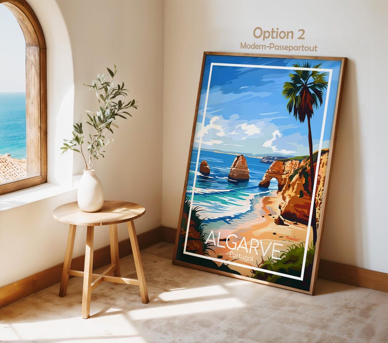 Pu&ograve; includere: Una stampa artistica incorniciata di una scena di spiaggia con il testo "ALGARVE Portugal". L'opera d'arte presenta un cielo blu, l'oceano, una spiaggia sabbiosa e una palma. La stampa &egrave; esposta in una stanza con un tavolino di legno e una finestra con vista sul mare.