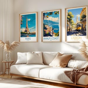 Pu&ograve; includere: Tre poster di viaggio incorniciati appesi a una parete. Il poster a sinistra mostra la Torre Eiffel a Parigi, Francia. Il poster centrale raffigura la Costiera Amalfitana in Italia con limoni. Il poster a destra mostra un tram giallo a Lisbona.