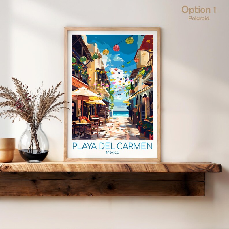 K&ouml;nnte beinhalten: Ein gerahmter Druck von Playa Del Carmen, Mexiko, mit einer lebendigen Stra&szlig;enszene. Das Kunstwerk zeigt farbenfrohe Geb&auml;ude, einen sonnigen Himmel und einen Blick auf das Meer. Der Druck ist mit "Option 1 Polaroid" beschriftet.