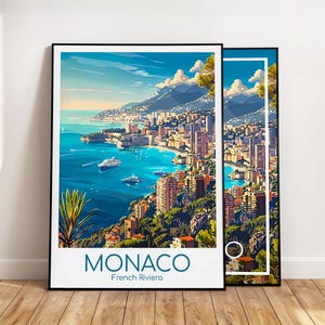 Puede incluir: Dos impresiones art&iacute;sticas enmarcadas representan un paisaje urbano costero con agua azul, edificios y monta&ntilde;as bajo un cielo brillante. Las impresiones presentan la palabra "MONACO" y "French Riviera" en un cuadro blanco en la parte inferior. Los marcos son negros.