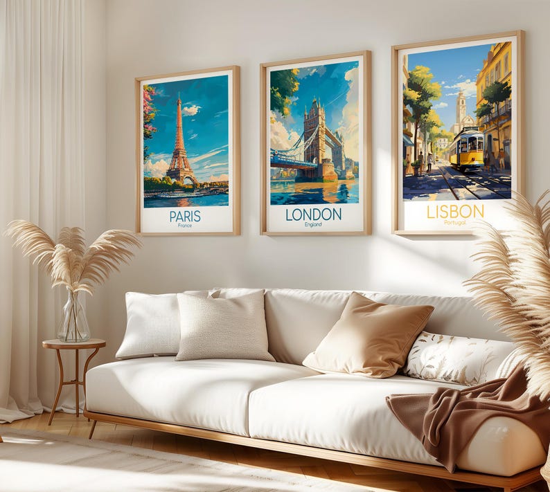 May include: Three framed travel art prints featuring iconic landmarks: the Eiffel Tower in Paris, Tower Bridge in London, and a yellow tram in Lisbon. Each print has a light wood frame and a white border, with the city name below.