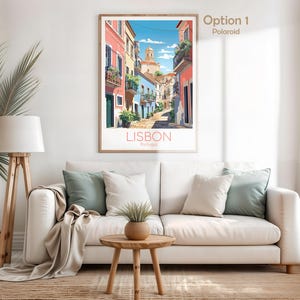 May include: A framed vertical wall art print depicting a sunny street scene in Lisbon, Portugal. The illustration features colorful buildings in shades of pink, blue, and yellow, with balconies, green plants, and a church tower under a blue sky.