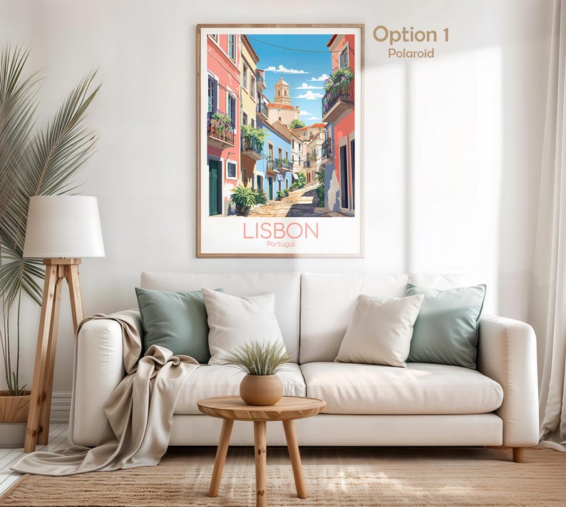 May include: A framed vertical wall art print depicting a sunny street scene in Lisbon, Portugal. The illustration features colorful buildings in shades of pink, blue, and yellow, with balconies, green plants, and a church tower under a blue sky.