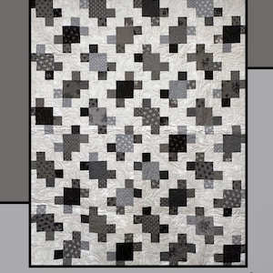 May include: A quilt with a repeating pattern of gray and black puzzle-piece shapes on a white background. The word "Puzzled" is at the top, with "Molly Cook for Villa Rosa Designs" at the bottom. The quilt has a floral pattern.