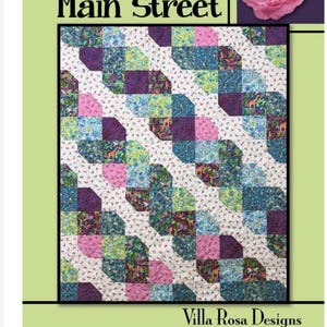 May include: A quilt pattern titled Main Street by Villa Rosa Designs featuring a repeating diagonal block layout. The quilt displays a variety of floral and animal print fabrics in shades of pink, blue, green, and purple, set against a white background.