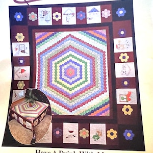 以下が含まれることがあります： 中央に六角形のデザインが施されたカラフルなキルトパターン。キルトは、刺繍された画像が施された小さな正方形のボーダーで囲まれています。キルトは77 1/2インチ×86インチです。キルトの下に「Have A Drink With Me」というテキストが印刷されています。