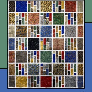 Può includere: Una colorata trapunta intitolata "Grated" con un design patchwork. La trapunta presenta quadrati di tessuto fantasia in rosso, blu, oro e verde, disposti a griglia. Il testo "Grated" è in giallo e il nome del designer è in basso.
