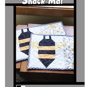 May include: A Buzzy Bee Snack Mat quilt pattern document featuring a graphic of a bee on a white background with yellow floral fabric accents. The text reads Buzzy Bee Snack Mat, Tricia Lynn Maloney, Orphan Quilt Designs, and for Villa Rosa Designs.