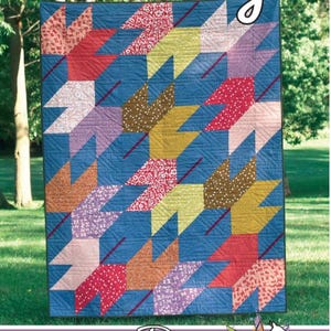 May include: A colorful quilt with a blue background and leaf-shaped patterns in various colors, including red, yellow, and purple. The quilt has the word "Falling" at the top and the Running Doe Quilts logo at the bottom.