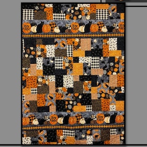 May include: A Halloween-themed patchwork quilt. The design incorporates orange, black, white, and grey squares with pumpkin and cat patterns. The words "Pumpkin Patch" are at the top, and "Trick or Treat" appears on some blocks. The quilt has a black border.