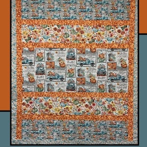 Op de afbeelding: Een quilt met herfstthema. De quilt heeft een herhalend patroon van pompoenen, vintage trucks en de woorden "Welcome", "Gather" en "Thankful". De quilt is omrand met oranje stof en heeft bovenaan de woorden "Pumpkin Pie".
