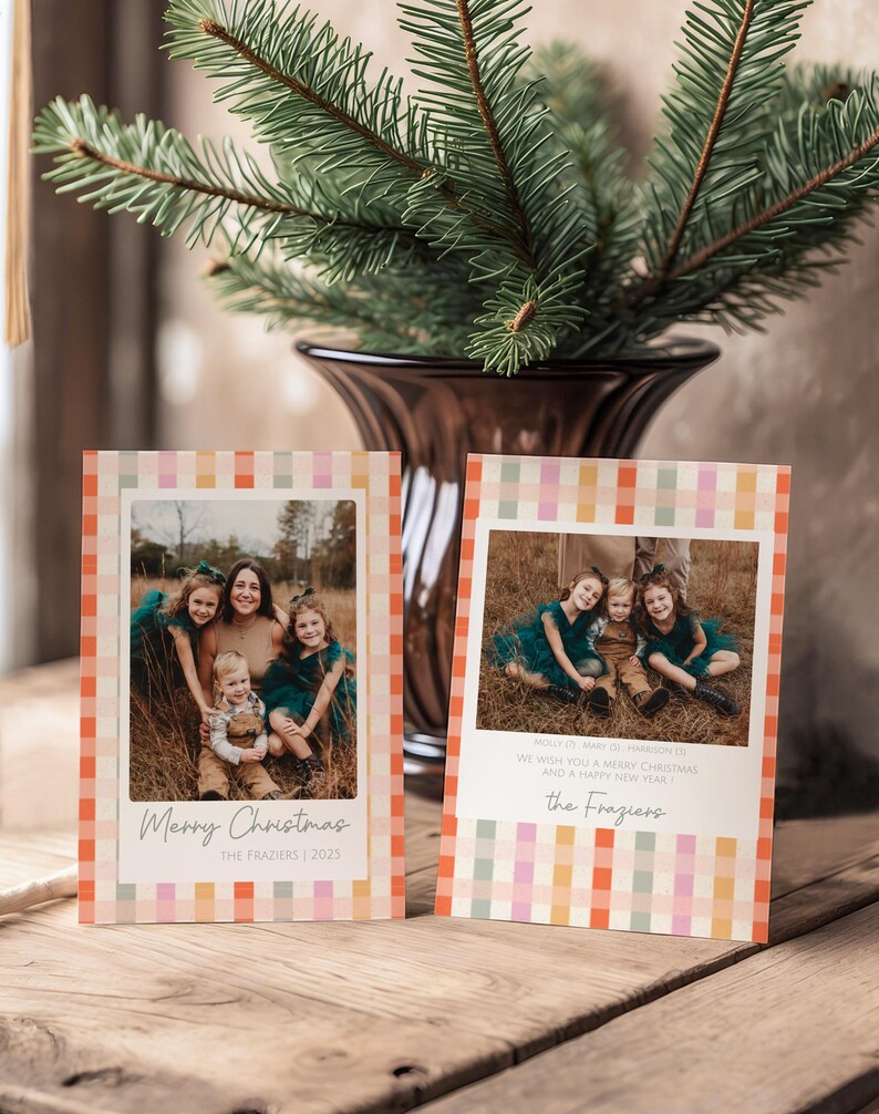 May include: Two holiday greeting cards with family photos, featuring a colorful plaid border. The cards have the text "Merry Christmas" and "We wish you a Merry Christmas and a Happy New Year". A vase with evergreen branches is in the background.