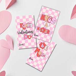 May include: Three pink and white checkered Valentine's Day cards with different messages. The first card says "Happy Valentines Day" with a pink heart and bow. The second card says "Hugs & Kisses" with a pink heart. The third card says "Be Mine" with a pink heart.