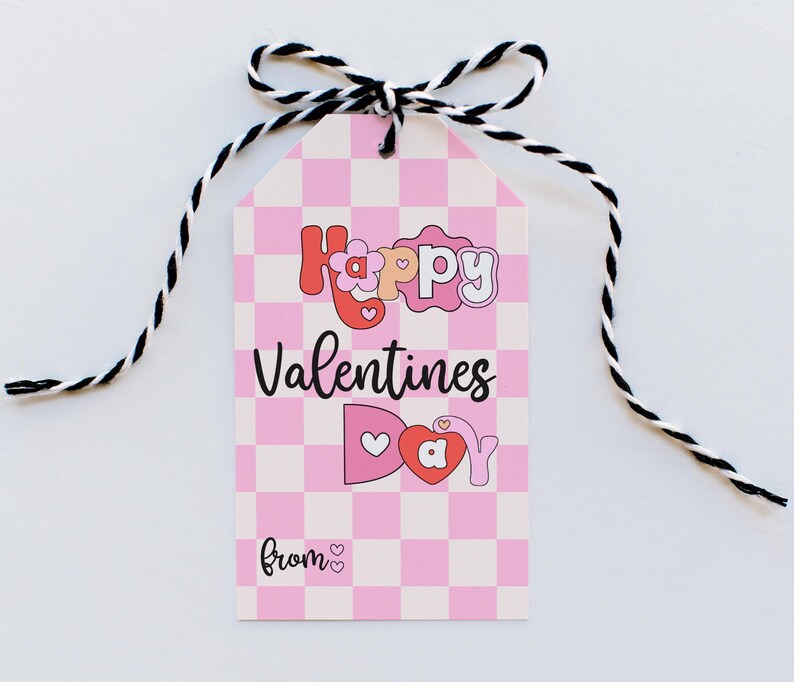 May include: A pink and white checkered gift tag with the text "Happy Valentines Day" in a colorful, playful font. The tag has a black and white twine bow and the text "from" with a heart.