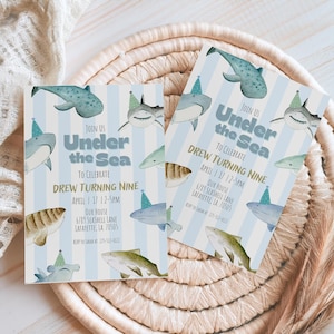 Op de afbeelding: Twee uitnodigingen voor een verjaardagsfeestje met een blauw-wit gestreepte achtergrond, met illustraties van haaien en walvissen. De tekst luidt "Under the Sea" en kondigt een feestje aan voor Drews negende verjaardag.