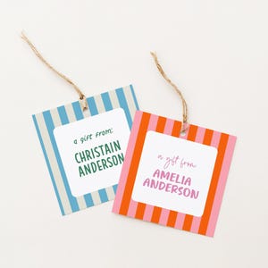 May include: Two square gift tags with striped patterns and twine strings. One tag has blue and white stripes with the text "a gift from: CHRISTAIN ANDERSON". The other tag has pink and orange stripes with the text "a gift from: AMELIA ANDERSON".