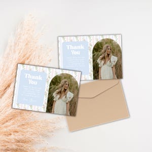 Op de afbeelding: Een set bedankkaarten met een lichtblauwe achtergrond en bloemaccenten. Elke kaart bevat een foto van een vrouw in een witte jurk. Een bruine envelop is inbegrepen. De tekst "Thank You" is zichtbaar op de kaarten.