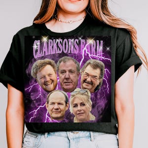 Puede incluir: Camiseta negra con un gráfico de cinco caras y el texto "Clarkson's Farm" en un diseño de rayos púrpura. La camiseta está hecha de un material suave.