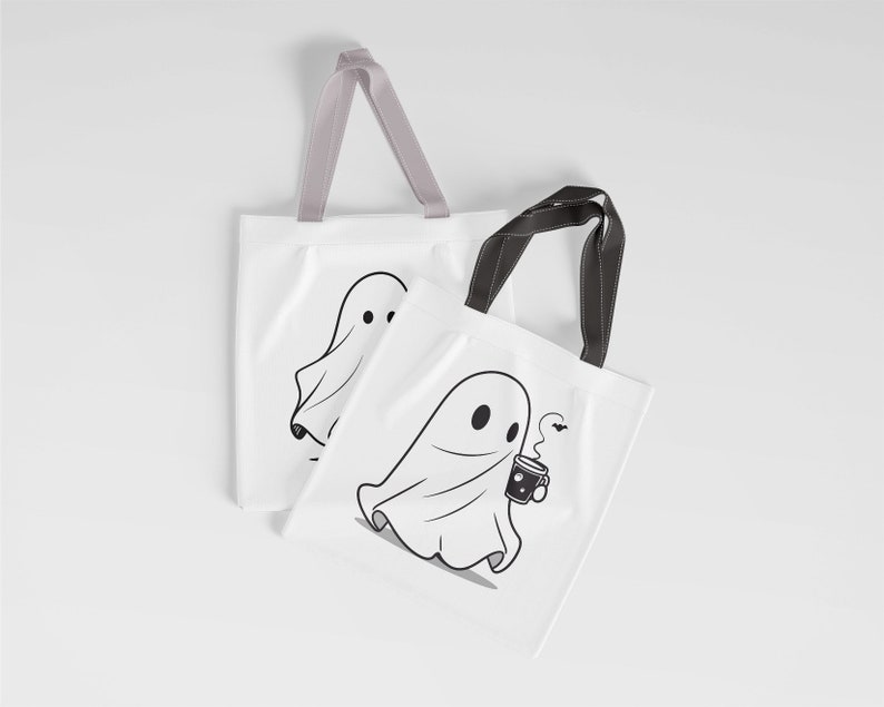 May include: Two white tote bags with black handles. One bag features a ghost holding a cup of coffee with a bat flying above. The other bag features a ghost with a simple design.