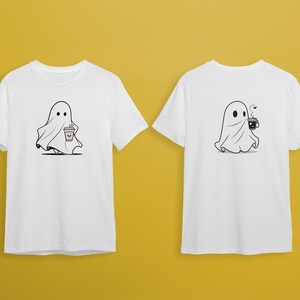 May include: Two white t-shirts with a ghost graphic. One ghost is holding a cup of coffee and the other is holding a cup of tea.