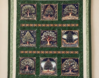 May include: A rectangular quilt featuring nine square panels, each displaying a different tree illustration. The panels are set against a dark green background with two horizontal decorative bands and a light green border frame.