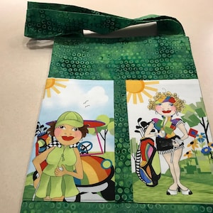 Sac fourre-tout 9,5 pouces de large 11,5 pouces de long, fait main vert. Deux poches extérieures avec imprimé golfeuse. Livre ou sac à lunch.