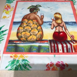 May include: Two women wearing swimsuits sit on a beach towel on a beach. One woman is wearing a pineapple print swimsuit and the other is wearing a red swimsuit. Both women are holding ice cream cones.