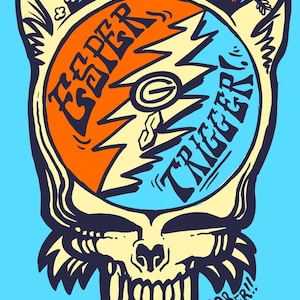 May include: A cartoon illustration of a skull with a split record on top. The record is orange and blue with the words "Grateful" and "Trigger" written on it. The skull has large teeth and is dripping with blue liquid. The text "Goldsaber!!" is written below the skull.