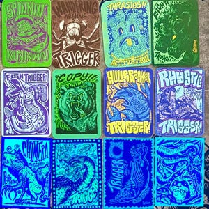 May include: Ten colorful trading cards with a variety of cartoon creatures and the word "Trigger" on each card. The cards are all different colors and have a variety of designs.