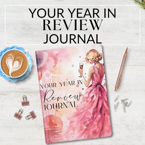Może przedstawiać: Różowy i biały notes w stylu akwareli z tekstem "Your Year in Review Journal" i kobietą w różowej sukience trzymającą kieliszek wina.